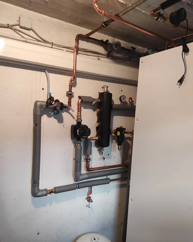 Hydraulische Weiche mit Absperrungen und Umwälzpumpe, sauber an der Wand montiert